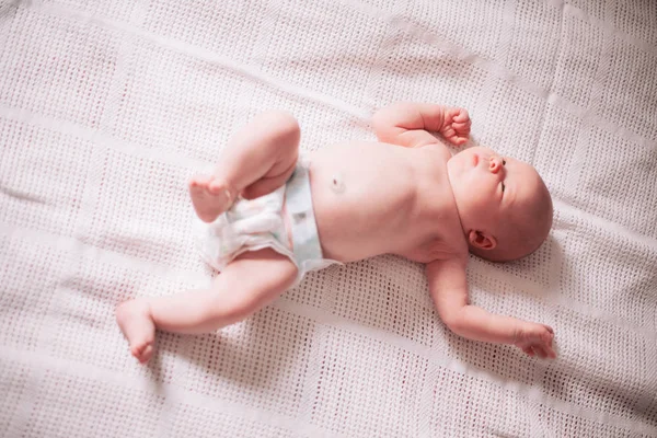 Κοντά. ένα όμορφο νεογέννητο μωρό κοιμάται σε μια άσπρη κουβέρτα. — Φωτογραφία Αρχείου