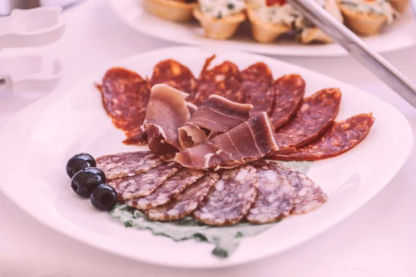 Slices of salami and meat on the festival table — Stock Photo, Image