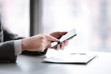 yakın kapatın. bir akıllı telefon üzerinde yazarak işadamı, Desk oturuyor
