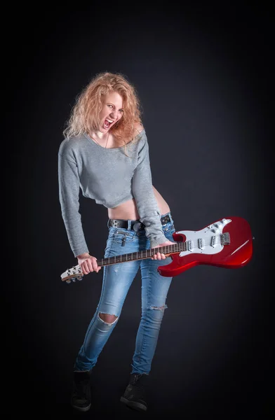 Emotivní rockový zpěvák se svou kytarou. izolované na tmavé — Stock fotografie