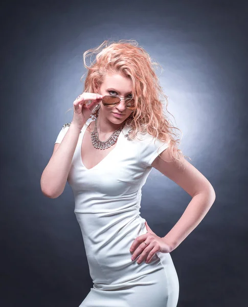 Mujer rubia de moda en vestido blanco mirando a través de gafas de sol —  Fotos de Stock