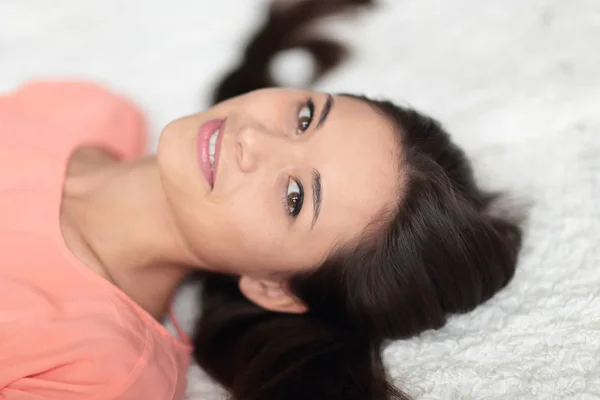 Close up.thoughtful mujer joven acostada en la alfombra blanca en la sala de estar — Foto de Stock