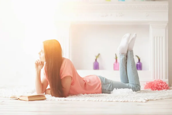 Retrato de niña leyendo libro tumbado en el suelo en la sala de estar — Foto de Stock