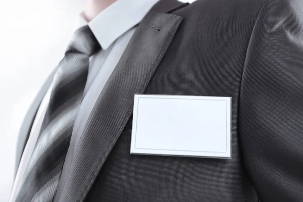 Blank identity tag hanging from a businessmans suit