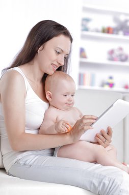 Anne ve bebek dijital tablet ekranına bakıyorlar.