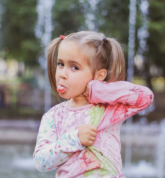 Niña mostrando la lengua en un paseo por el parque — Foto de Stock