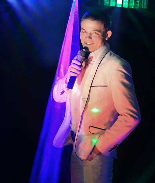 Young showman with a microphone in a nightclub — Stock Photo, Image