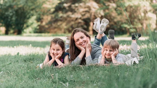 funny mom with her kids on the lawn on a summer day