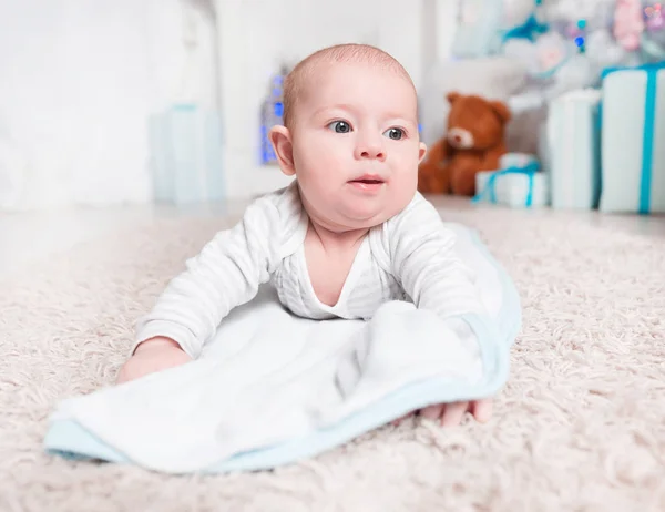 Ładne dziecko leżące na dywanie w salonie przytulne — Zdjęcie stockowe