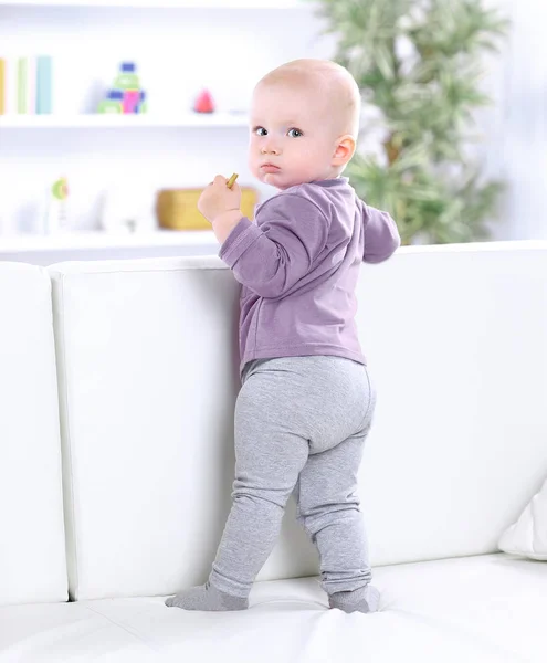 Retrato de bebê bonito em pé no sofá . — Fotografia de Stock