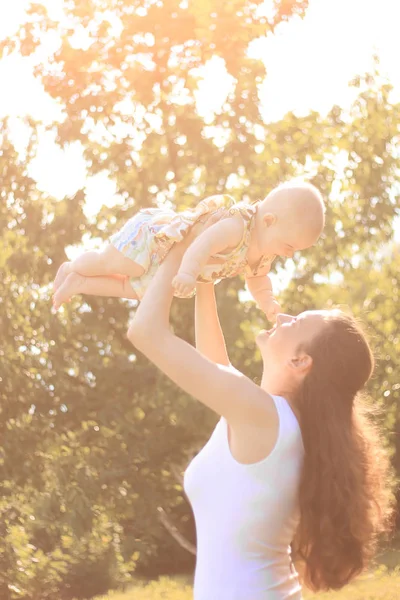 Щаслива мама грає зі своєю маленькою донькою в літньому парку — стокове фото