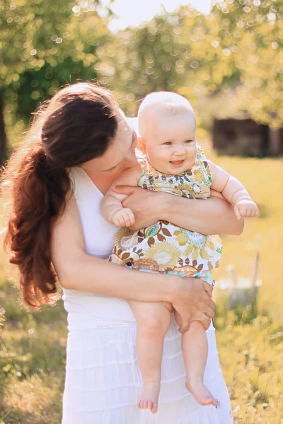 Mãe feliz segura uma pequena filha em seus braços — Fotografia de Stock