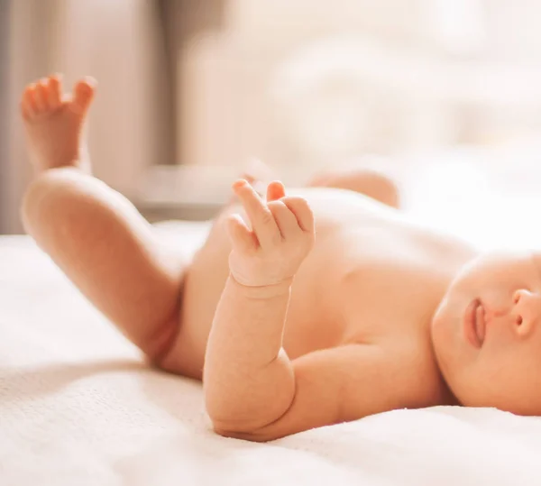 Beyaz bir battaniye üzerinde yatan sevimli yenidoğan bebek. — Stok fotoğraf