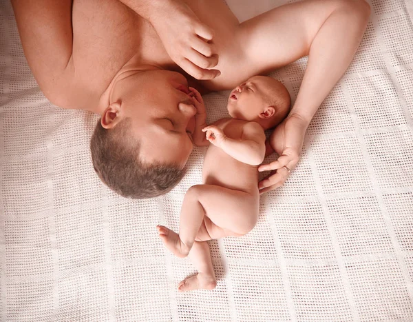 Father with his newborn daughter lying on the bed. — Stock Photo, Image