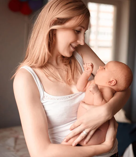 Feliz mamá sonríe a su bebé recién nacido  . — Foto de Stock