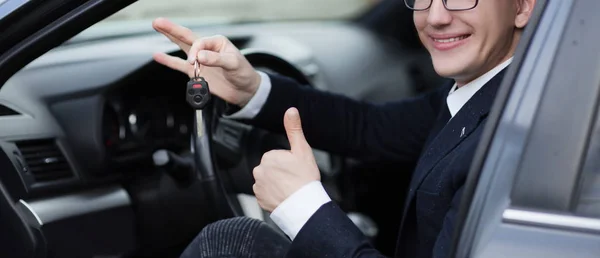 Glücklicher Fahrer zeigt Daumen nach oben, während er im Auto sitzt — Stockfoto