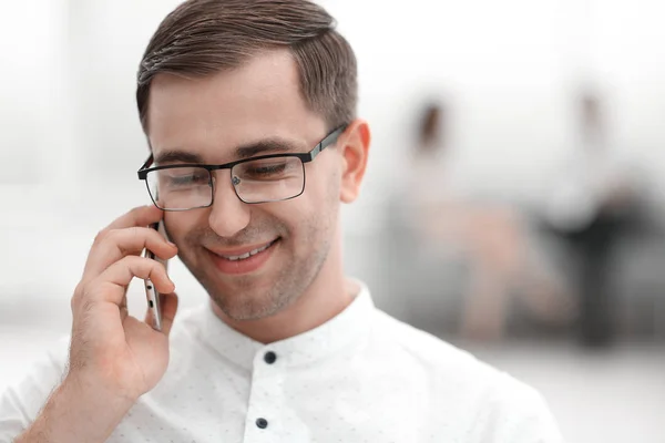 Close up. smiling businessman talking on his smartphone — стоковое фото