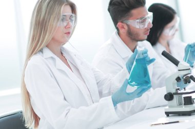 Yakın çekim. Genç bilim adamları sıvı üzerinde deney yapıyorlar.