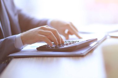 yakın kapatın. işadamı hesap makinesi üzerinde hesaplamalar yapar