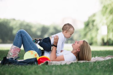 Anne ve küçük oğlu birlikte, çim üzerinde yalan oynamak .
