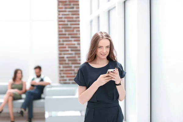 Ung kvinne bruker smarttelefonen på kontoret – stockfoto