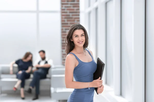 Ung affärskvinna med Urklipp stående i office lobby — Stockfoto