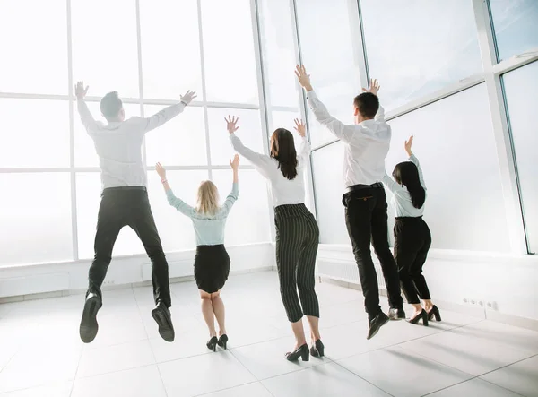 Posteriore view.happy business team, divertirsi in un nuovo ufficio luminoso . — Foto Stock