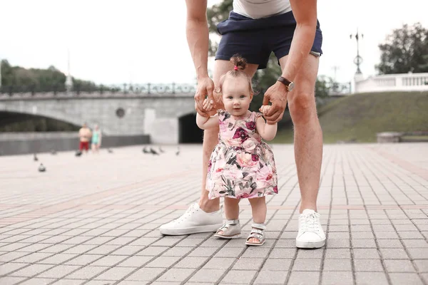 Niño aprende a caminar. El padre sostiene al niño y le enseña a caminar. — Foto de Stock