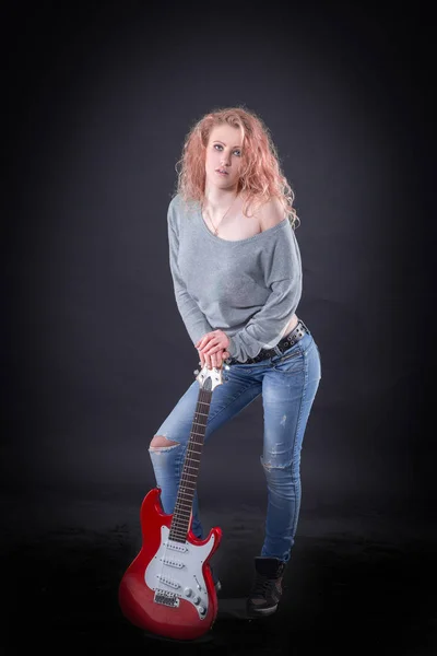 Рок-певец с гитарой, стоящей на сцене — стоковое фото