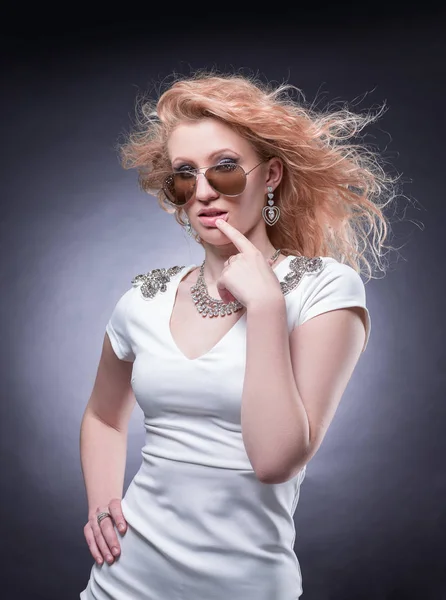 Modische blonde Frau mit Sonnenbrille. isoliert auf einem dunklen — Stockfoto