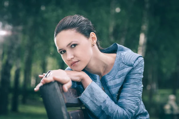 Bir bankta oturan sevimli genç kadın — Stok fotoğraf