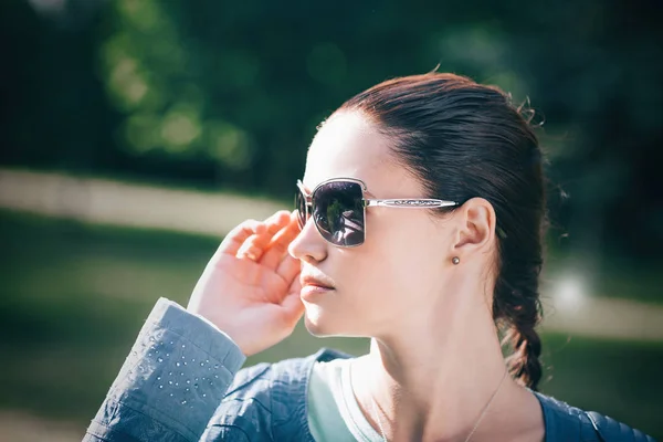 Närbild. vacker ung kvinna som tittar genom solglasögon — Stockfoto