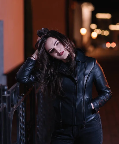 gece şehirde kaldırımda duran sevimli genç kadın