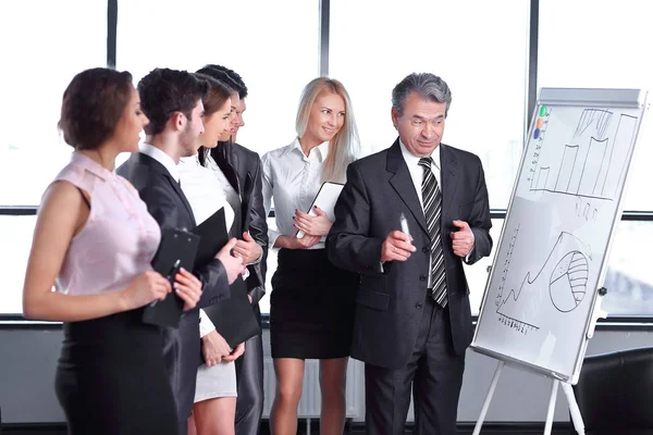 Grupo de gente de negocios mirando el gráfico en Flipchart —  Fotos de Stock