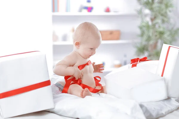 Infant child baby toddler kid sitting in presents gift for celebration — Stock Photo, Image