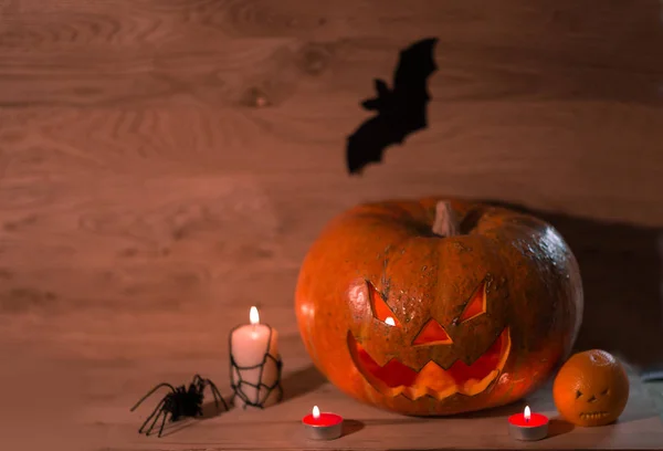 Velas, calabazas y una araña sobre un fondo de madera —  Fotos de Stock