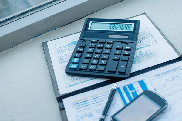 Calcolatrice, smartphone e documenti finanziari sul business — Foto Stock