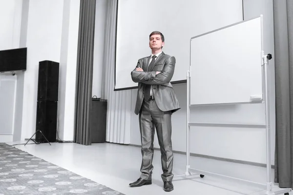 confident businessman standing on stage in the conference hall