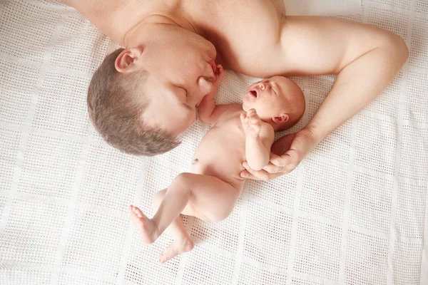 Vader met zijn pasgeboren dochter slapen op het bed — Stockfoto