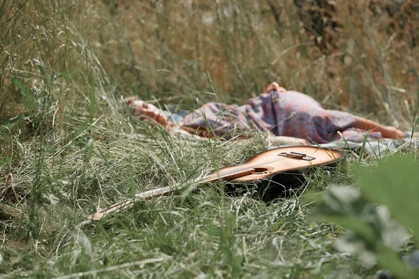 yaz gününde doğada gitar ve uyuyan hippi kız