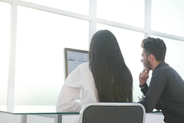 Achterste view.business paar zitten op een desktop computer. — Stockfoto