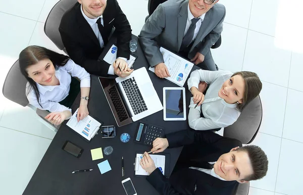 Top View.Business-Team am Schreibtisch mit Blick in die Kamera — Stockfoto