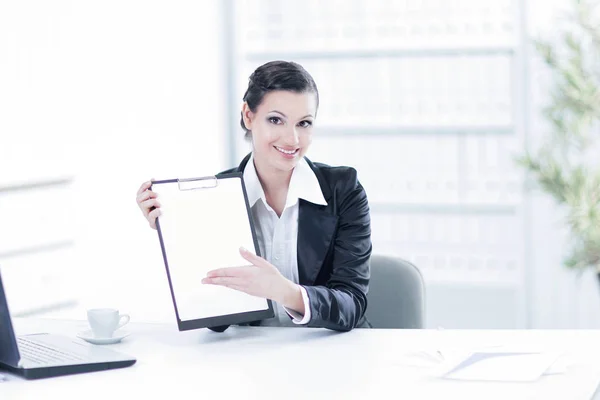 Femme d'affaires exécutive montrant feuille blanche, assis à son bureau — Photo