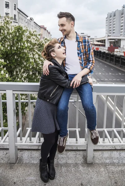 Портрет любящей пары, стоящей на мосту в большом городе — стоковое фото