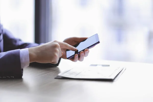 Nahaufnahme. Geschäftsmann tippt auf dem Smartphone, sitzt am Schreibtisch — Stockfoto