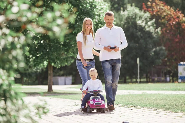 Mamá, papá e hijo caminando por un camino en un parque de la ciudad . —  Fotos de Stock