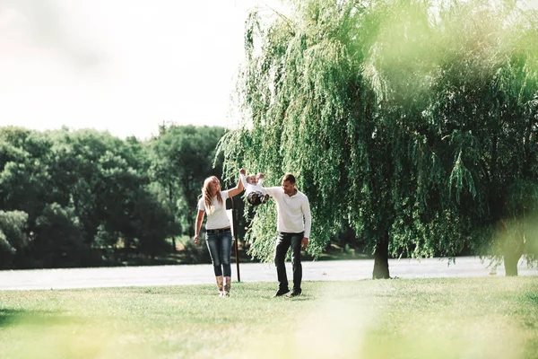 Padres con su hijo pequeño caminando en el parque de primavera . —  Fotos de Stock