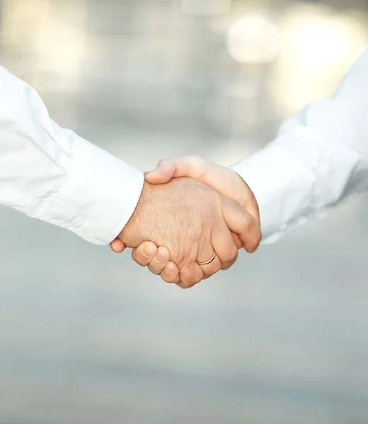 Närbild. Handshake affärsmän i suddig bakgrund. — Stockfoto