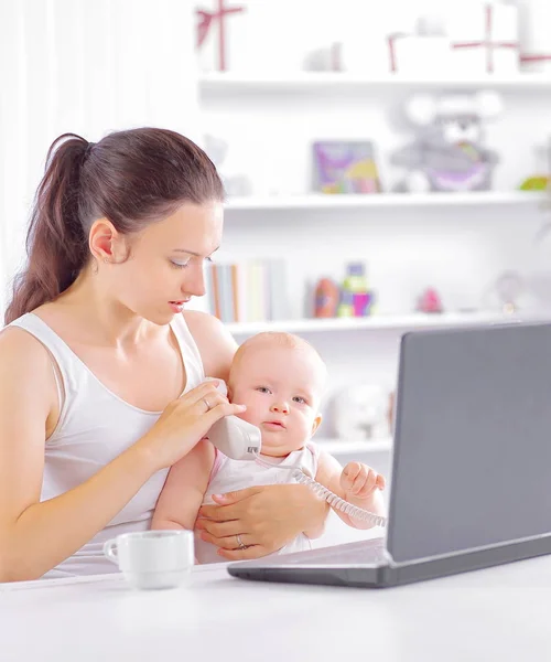 Jeune maman donne bébé une écoute à la conversation téléphonique — Photo