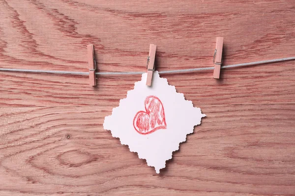 Papper med ett hjärta som ritas på en klädnypa. — Stockfoto